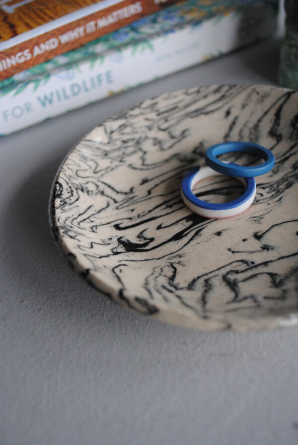 Marbled ceramic dish with black patterning.