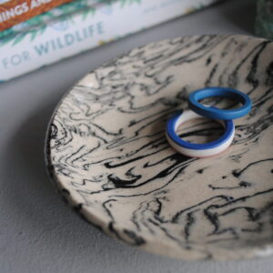 Marbled ceramic dish with black patterning.