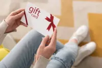 stock-photo-cropped-view-girl-holding-gift-card-red-bow